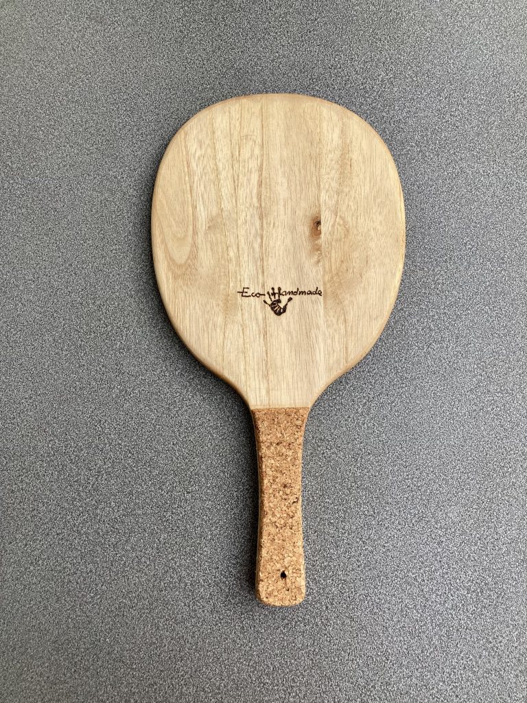 Eco-friendly Frescobol paddle with a smooth paulownia wood surface, ergonomic cork handle, and engraved logo for a sustainable touch