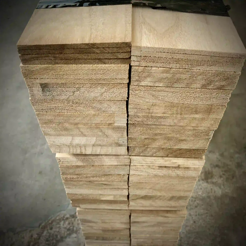 Stack of precisely cut Paulownia wood sheets, showcasing their uniform grain and lightweight structure. Ideal for surfboards and eco-friendly applications.